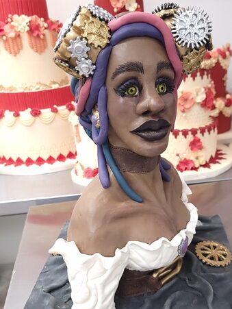 Custom cake of a black woman's head and bust with pink and purple hair in Kitchener Ontario